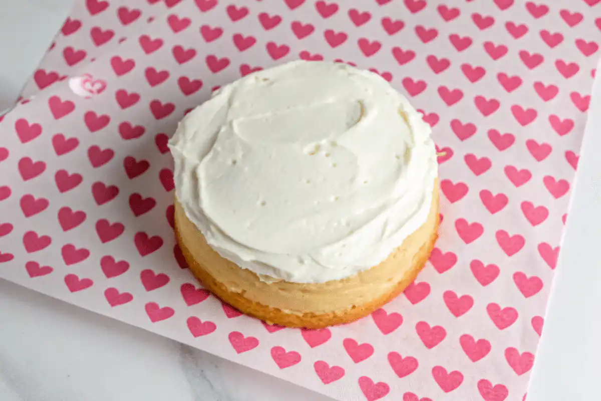 Single mini cake layer with smooth white frosting