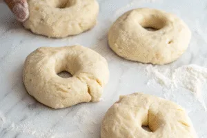 Shaped dough for high protein bagels on floured surface