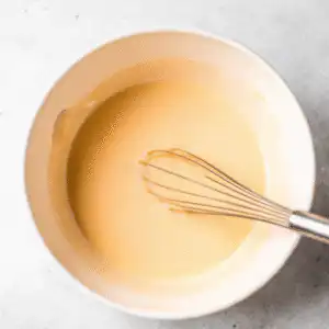 Whisking banana, eggs, and honey for muffin batter