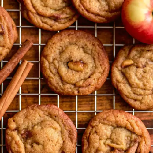 Apple Snickerdoodles with Caramelized Apples & Brown Butter Apple Snickerdoodles Chewy apple snickerdoodles with caramelized apples and brown butter cooling on a wire rack with cinnamon sticks and a fresh apple