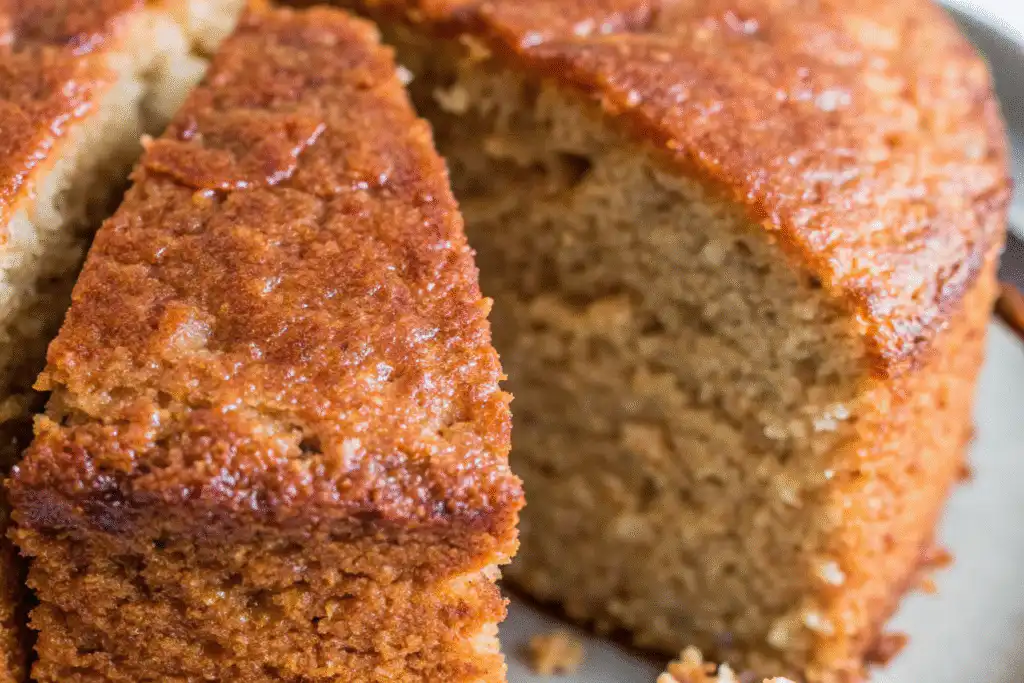 Golden banana butter cake loaf sliced to reveal a moist, fluffy crumb and caramelized edges, perfect for tea time.