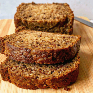 Moist Zucchini Bread – Fluffy, Freezer-Friendly & Easy to Bake! moist zucchini bread Close-up of moist zucchini bread slices stacked on a wooden board with a golden crust.