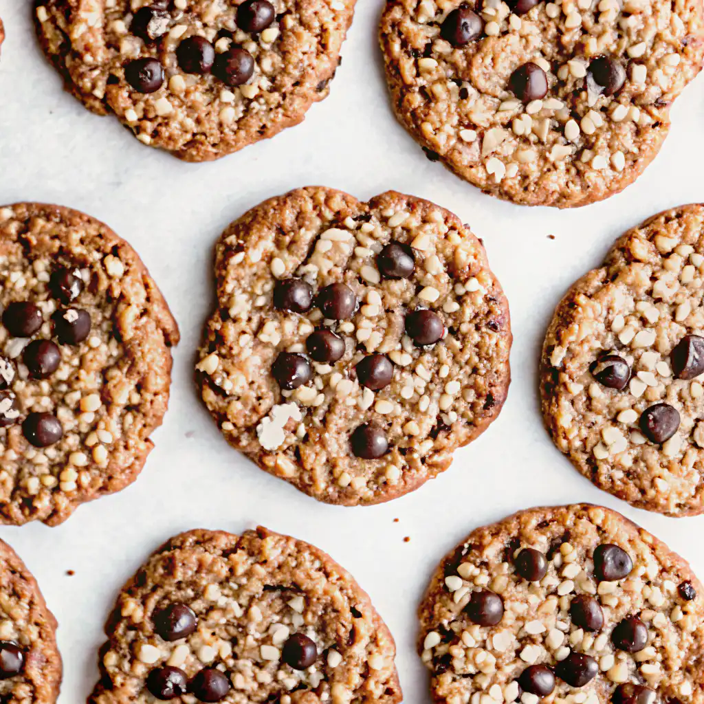 Close-up of chewy oatmeal chocolate chip cookies with oats and melty chocolate chips on a white surface