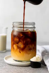 Cold espresso poured into milk and ice for iced protein coffee
