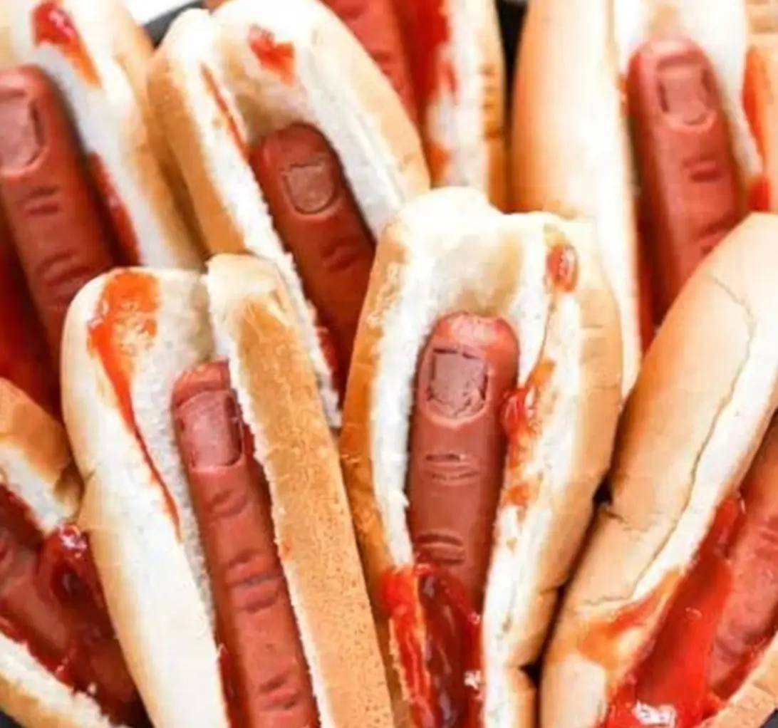 bloody-finger-hot-dogs-halloween-snack Halloween bloody finger hot dogs with carved knuckle details, topped with ketchup “blood” and served in buns.