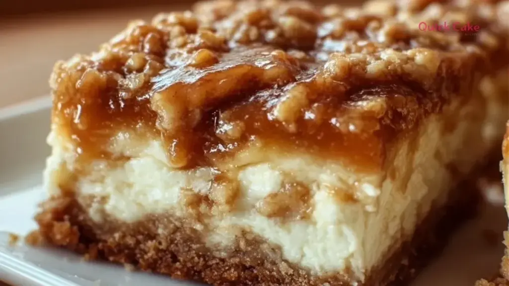 Decadent caramel apple cheesecake bars topped with caramel sauce and apple slices.