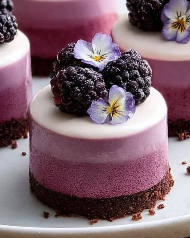 Delicious no-bake blackberry mousse cakes beautifully presented on a dessert table