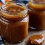 Canned pumpkin butter in glass jars on kitchen counter.