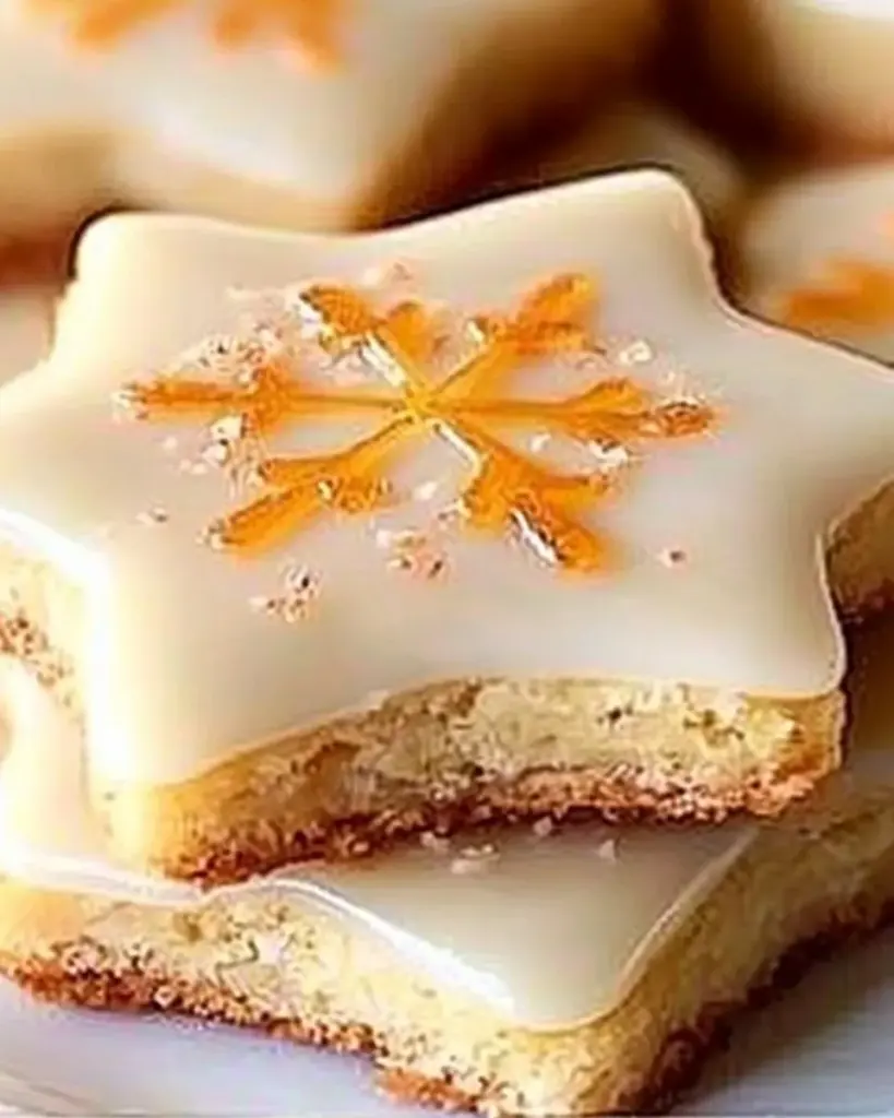 Delicious cardamom shortbread cookies topped with orange glaze on a plate