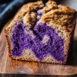 Vegan marbled ube banana bread slice showing vibrant purple and yellow layers.